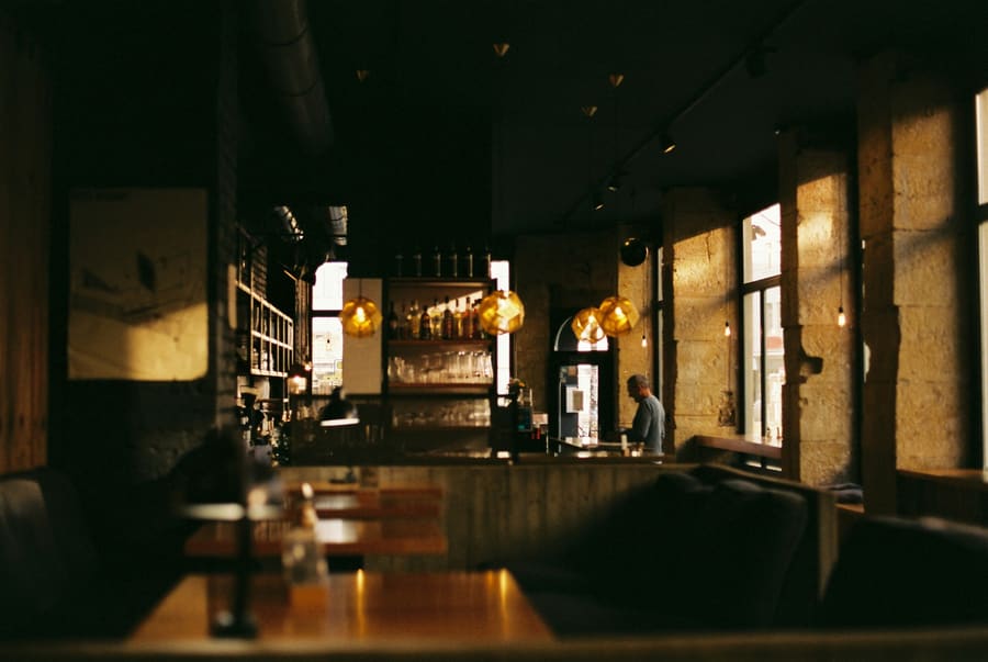 Een donkere wijnbar met kaarslicht op de tafels